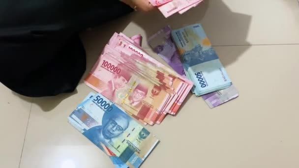 印度尼西亚 苏拉巴亚 2023年7月11日 女性的双手在地板上数着成百上千卢比的钞票 — 图库视频影像