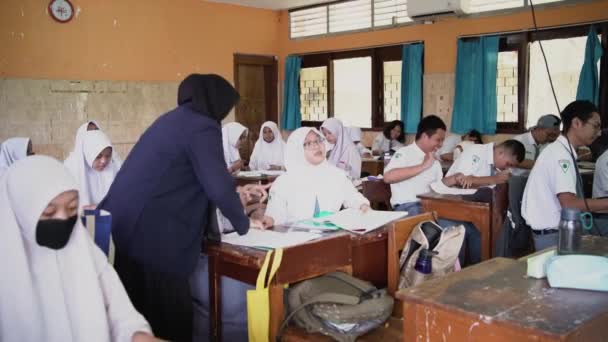 2023年5月29日 インドネシアのスラバヤ 高校生が教室で一緒に勉強する 若いムスリム女性教師が学校の子供たちと教える — ストック動画