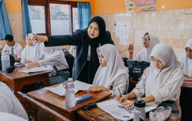 Surabaya, Endonezya, 29 Mayıs 2023 - Asyalı Müslüman kadın öğretmen çocuklara lisede resim dersi veriyor. Okulda öğretim ve öğrenim süreci kavramı.