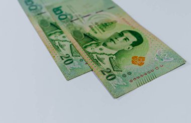20 baht değerinde iki Tayland banknotu, beyaz arka planda izole edilmiş..