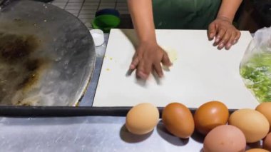 Martabak Telor 'u hazırlıyorum. Yumurta, et ve baharatla doldurulmuş tuzlu tavada kızartılmış hamur işi. Martabak, Endonezya 'da (Endonezya) popüler bir yiyecek alımıdır. Seçici odak.