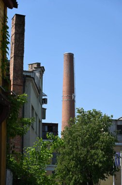 Şehrin üzerinde uzun, yuvarlak bir baca yükseliyor.