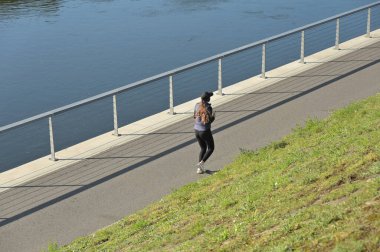 Şehirde koşan genç bir kadın.