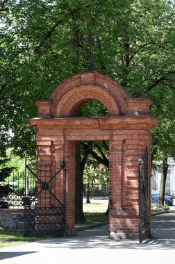 Mavi gökyüzünün arka planında kemer olan eski tuğla kapı