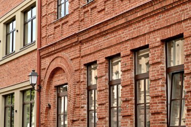 Kırmızı tuğladan pencereleri ve tuğladan duvarı olan bir evin ön cephesi