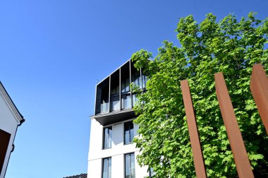 Balkonu olan modern bir apartmanın ön cephesi.