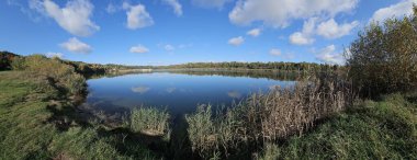 Mavi gökyüzü, bulutlar ve yansıması olan güzel göl..