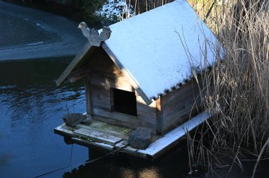Kışın nehir kıyısında küçük bir kuş evi.