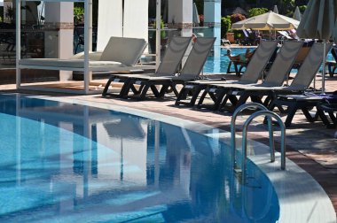 Otel odasında boş havuz ve sandalyeler