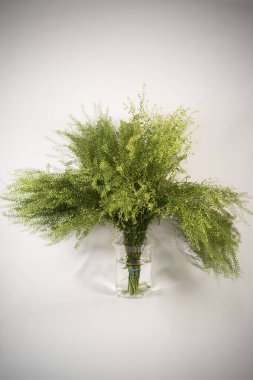 Yeşil çimenli güzel bir buket ve bir bardak su.