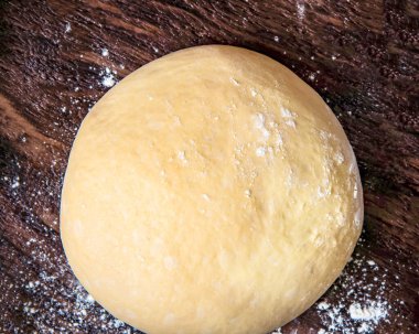 Ahşap arka planda taze çiğ hamur topu, üst manzara.