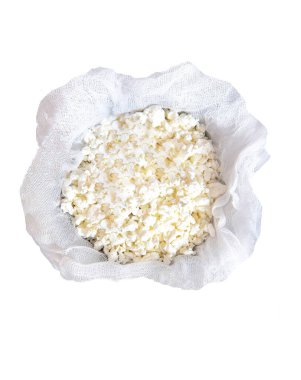 Beyaz arka planda izole edilmiş gazlı bezle ev yapımı taze süzme peynir..