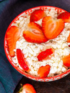Siyah arka planda çilekli süzme peynir. Sağlıklı bir tatlı. Üst görünüm.