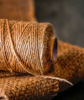 Doğal jüt sicim rulo, siyah arka plan üzerine çuval bezi. Malzemeleri ve el yapımı hobi eğlence closeup için Araçlar