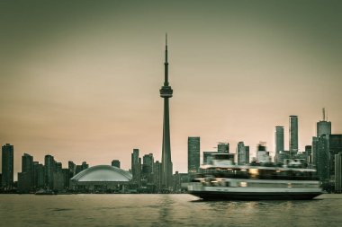 Skyline of Toronto with the Toronto Islands Ferry. Blurred ferry to imply motion. Green toned. clipart