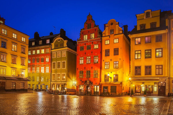 Clear blue dusk sky above the colourful townhouses and quaint restaurants of the historic Stortorget square. Stortorget is the iconic landmark square on Gamla Stan in the heart of Stockholm, Sweden