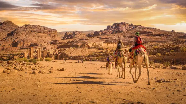 骑骆驼前往约旦Petra的Colnaded街Temenos门的游客 — 图库照片