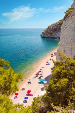 Renkli plaj şemsiyeli Baia delle Zagare (Zagare Körfezi) veya Baia dei Mergoli (Mergoli Körfezi) manzarası, Gargano Ulusal Parkı, Puglia, İtalya