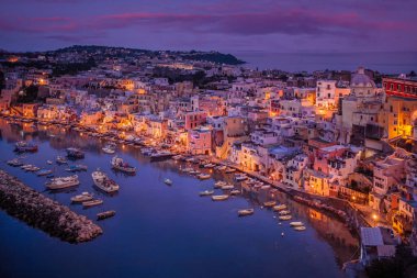 Marina Corricella Alacakaranlık, Procida, Napoli, İtalya 'da. Procida 'nın en eski balıkçı köyü olan Corricella doğal bir amfitiyatro üzerine kurulmuş ve dinlenmeyi tercih edenler için sakin bir sığınak. .