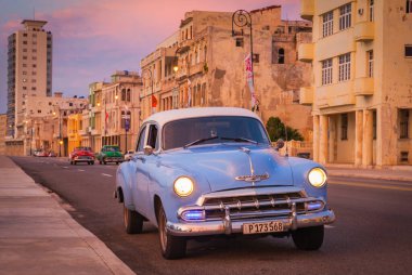Eski Chevrolet Deluxe gün batımında Malecon 'dan geçiyor, Havana, Küba
