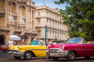 Beautiful vintage cars in front of colonial buildings clipart