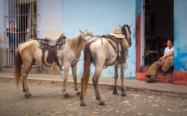 Kübalı bir kovboy, yağmur ormanları Trinidad, Küba 'daki turistik bir turdan sonra bunaltıcı bir yaz gününde evinin kapısında dinleniyor.