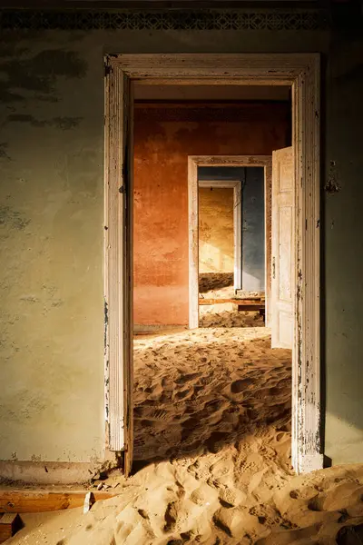 纳米比亚Kolmanskop一座废弃建筑的内部 被沙子吞没 被纳米比亚沙漠的暖光照亮 该城始建于1908年 是为了勘探钻石 1956年被废弃 — 图库照片