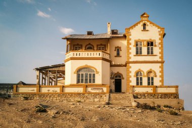 Kolmanskop hayalet kasabası Namibya 'daki Minenverwalters Haus (Mayın Yöneticisi Evi), Alman modeli üzerine inşa edilmiş büyük bir malikanedir. Film ve TV yapımları için popüler bir ortam haline geldi..