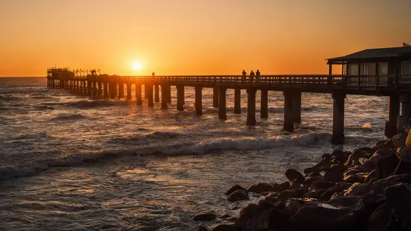 stock image Colorful sunset over the old historic Jetty of Swakopmund, Namibia. Built in 1905, it is now open to visitors after renovation works in 1985