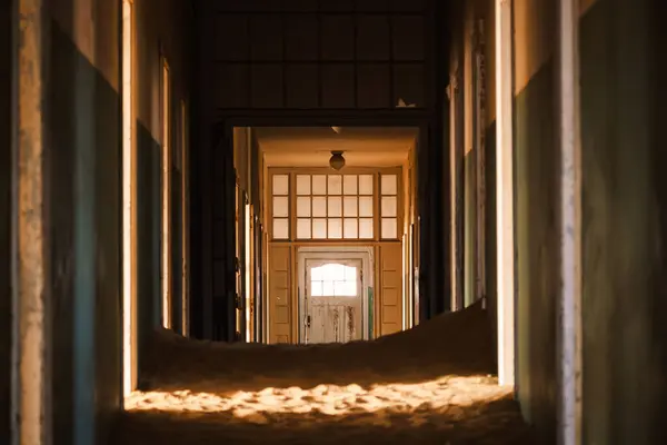 Namibya 'nın Kolmanskop kentindeki terk edilmiş hastanenin içini kum kaplamış ve Namib Çölü' nün sıcak ışığı aydınlatıyor. 1908 'de elmas keşfi için kurulan kasaba 1956' da terk edildi..