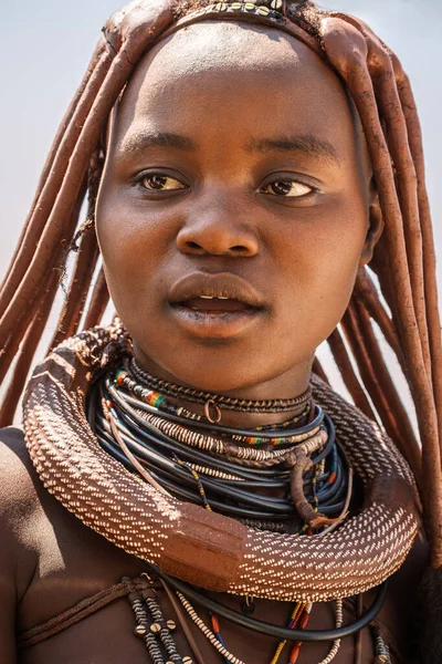 Opuwo, Namibya 'nın kuzeyinde, çerçeveden dışarı bakan genç Himba kadını. Himba yarı göçebe bir Afrika kabilesidir. Eski geleneklerini canlı tutmuşlardır..