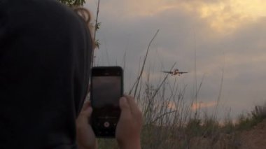 Eşofmanlı tanınmayan bir genç, uçak inişe geçerken cep telefonunda bir video kaydediyor.