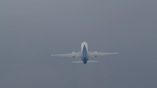 乗客の飛行機は灰色の曇った空の背景に対して高度を得る — ストック動画