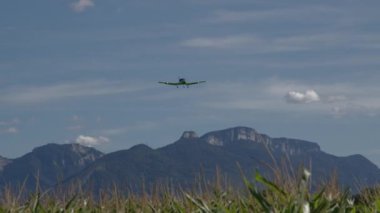 Işık pervaneli uçak Fransa 'da uçar, çerçevesinde uzun çimenler, dağlar ve mavi gökyüzü bulunur. Pervane düzleminin bir deneme uçuşu, çerçeveye doğru uçuyor ve iniyor.