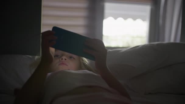 Ein Sechsjähriges Blondes Mädchen Das Auf Einem Bett Liegt Lässt — Stockvideo