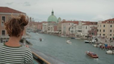 Çizgili gömlekli bir genç, arka planda San Simeone Piccolo kilisesi olan Büyük Kanal 'ın panoramik görüntüsünü yakalar.