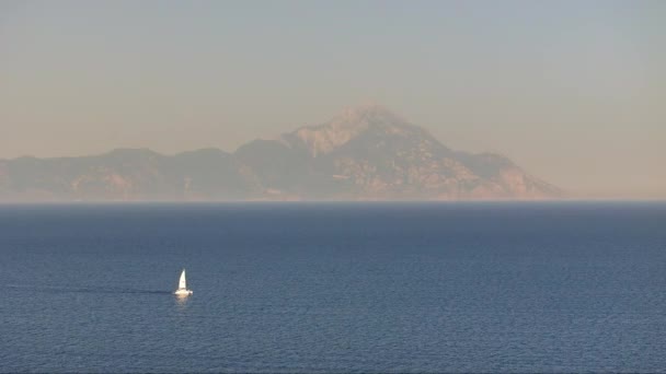 ギリシャの山々の素晴らしい風景に囲まれた広大な海を平和的に見渡す帆船の空中撮影 — ストック動画