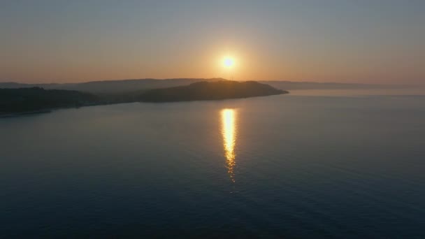 日の出に穏やかな海水の上に進むドローン — ストック動画