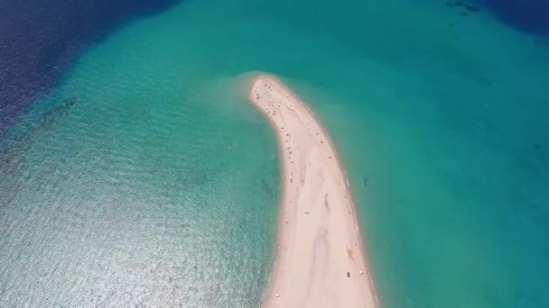 一架无人驾驶飞机飞越希腊哈尔基迪基波西迪的沙滩角上 捕获了一个被碧绿海水环绕的沙洲 周围有可见的海床和海滩游客 — 图库视频影像