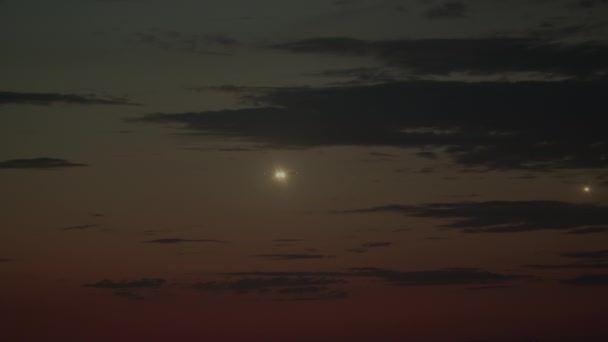 两架飞机在明亮的着陆灯的指引下 在昏暗的天空中飞行 地平线上升起红色的落日 飞往机场着陆 — 图库视频影像
