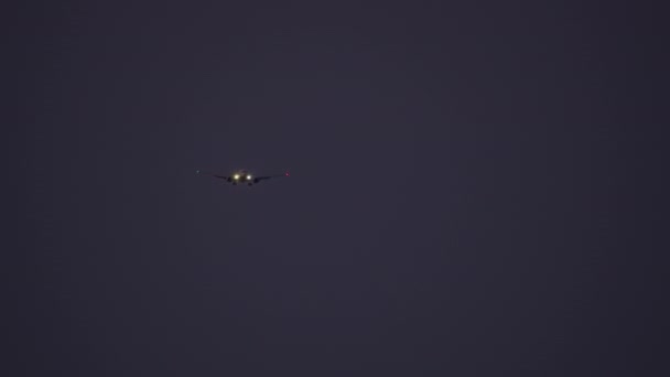 ナビゲーションライトを搭載した飛行機が暗い夜空に向かい 目に見えるランディングギアと下腹部の詳細で着陸する準備 — ストック動画