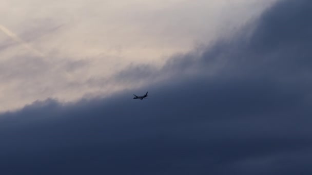 Silhouetted Samolot Wykonujący Zwrot Wchodzący Gęstą Formację Ciemnych Chmur Niebie — Wideo stockowe