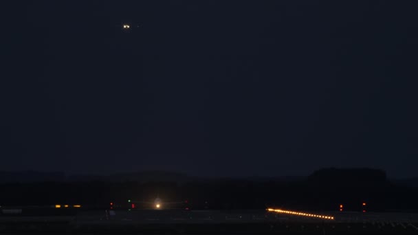 Ένα Αεροπλάνο Ανεβαίνει Από Διάδρομο Φωτεινά Φώτα Ενώ Ένα Άλλο — Αρχείο Βίντεο
