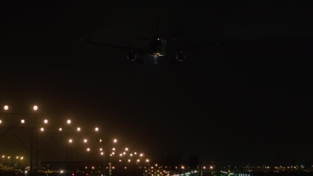着陸の瞬間に捕らえられた飛行機は 夜にその降下を導く明るい滑走路ライトと — ストック動画