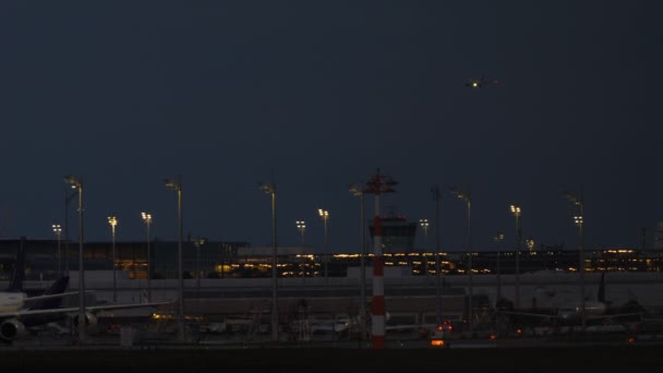 Avión Con Luces Aterrizaje Acercarse Una Terminal Aeroportuaria Por Noche — Vídeo de stock