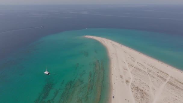 ドローンは ギリシャのハレキキ島の海岸近くの狭い砂 澄んだ浅い水 散らばったビーチゴーバー 孤独なボートを示すポシディ岬を捕獲します — ストック動画