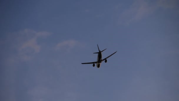 俯瞰喷气式飞机的下腹部 飞机在降落过程中 在晴朗的蓝天下留下了伸展翼 — 图库视频影像