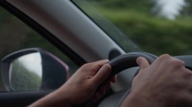 Eller direksiyona yakın ve yan ayna dışarıdaki çevreyi yansıtıyor.