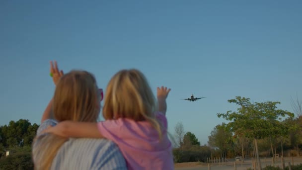 Una Madre Hija Con Los Brazos Levantados Saludando Avión Volando — Vídeo de stock