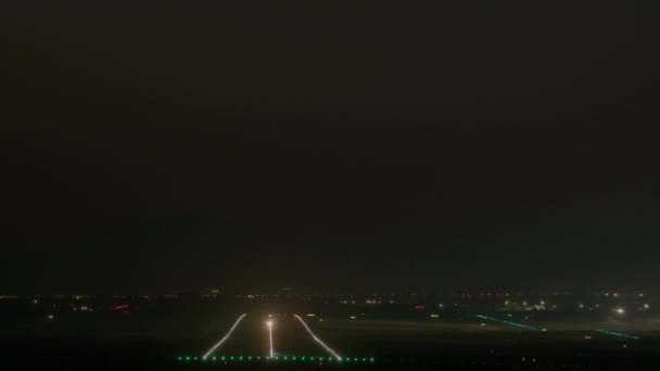 飛行機は暗い夜空に上昇し ランウェイライトは 距離で街の輝きを持つライト航空機につながる — ストック動画